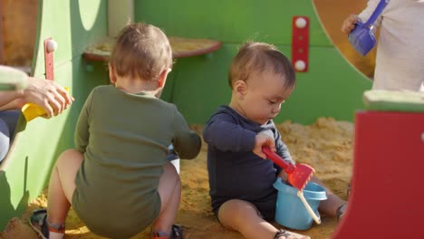 Tres-niños-pequeños-jugando-al-aire-libre-en-sand-Pit