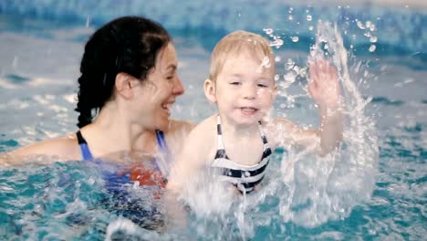 Schwimmbad.-Mama-bringt-einem-kleinen-Kind-das-Schwimmen-im-Pool-bei.