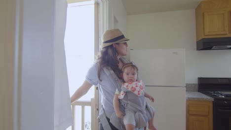 Mujer-con-bebé-mirando-alrededor-de-un-apartamento-vacío