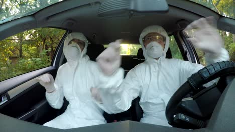 Funny-concept-of-two-young-hazmat-scientists-workers-in-car-dancing-and-driving-to-contaminated-location