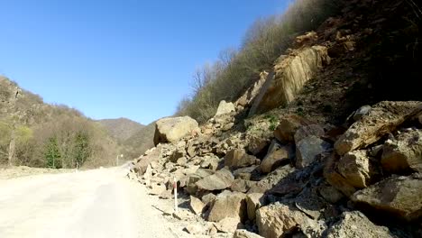 road-is-blocked-by-a-land-slide-of-rock-and-debris-to-where-it-is-a-hazard-for-drivers-in-cars