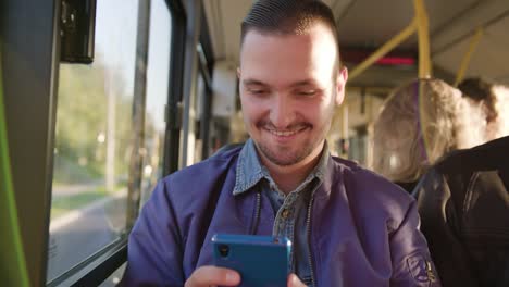 Un-hombre-joven-con-un-Smartphone-en-el-Bus