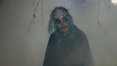 Crazy-evil-halloween-clown-coming-up-from-a-foggy-wood-and-doing-a-ritual-dance-to-frighten-people