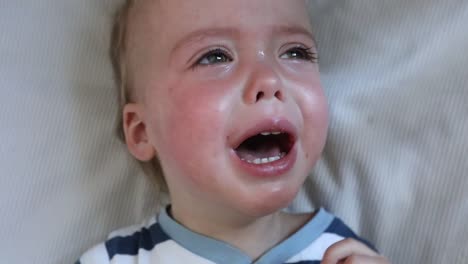 Face-crying-baby-boy-in-crib-at-home