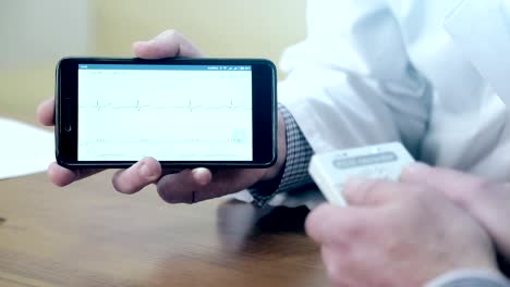 A-Doctor-demonstrates-a-cardiogram-on-the-mobile-phone