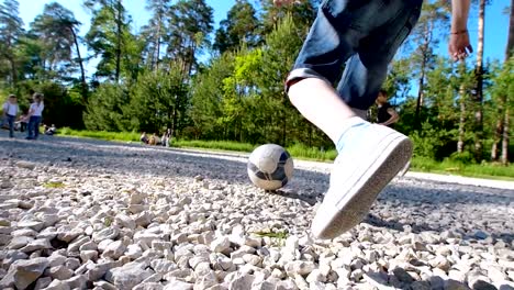 Group-of-teenagers-running-after-the-ball-playing-yard-football-in-summer-day-in-the-park