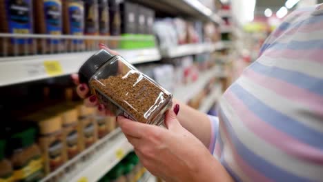 Closeup-caucasian-woman-near-shop-shelves-choosing-instant-coffee-in-grocery-market