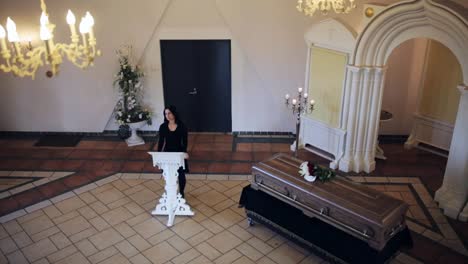 traurige-Frau-und-Sarg-bei-Beerdigung-in-der-orthodoxen-Kirche