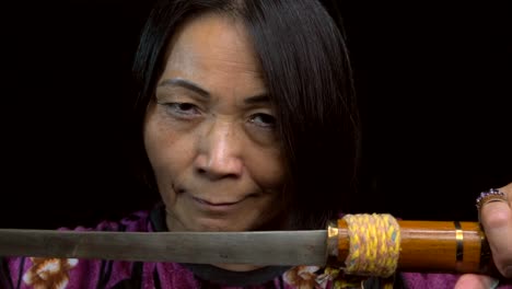 close-up-of-old-asian-woman-opening-sword