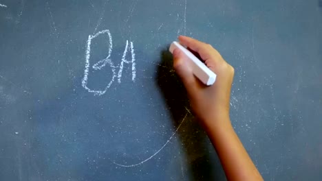 Child's-hand-writes-on-the-chalkboard-words-"Back-to-School!"