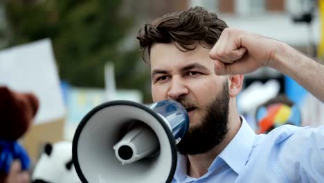 Adulto-joven-grita-en-el-megáfono.-Gente-caucásica-grita-violentamente-y-enojado.