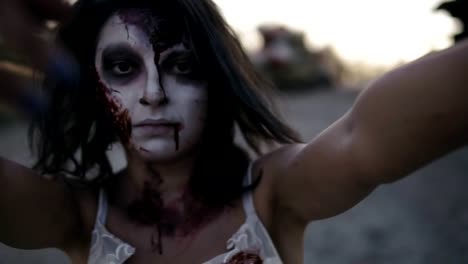 Porträt-einer-gruseligen-Zombie-Frau-mit-Verwundeten-Gesicht-walking-im-Freien-mit-einem-industriellen-verlassenen-Platz-auf-dem-Hintergrund.-Halloween,-Dreharbeiten,-gruselige-Konzept