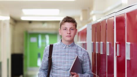 Retrato-de-estudiante-de-secundaria-de-hombre-caminando-por-el-pasillo-y-sonriendo-a-cámara