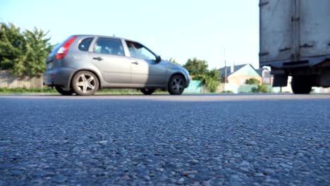 Cars-drive-along-highway-in-countryside.-View-on-the-country-road.-Traffic-close-up.-Low-angle-view-Slow-motion