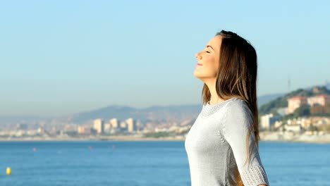 Perfil-de-una-mujer-respira-sonriendo-en-la-playa