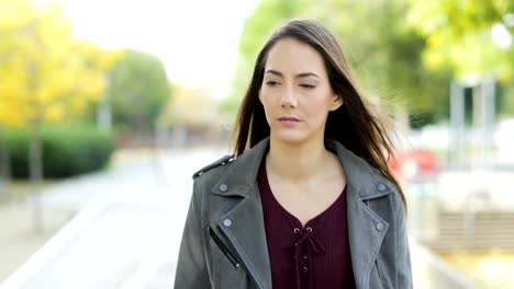 Serious-pensive-woman-walking-in-a-park