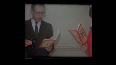 1963-jüdischen-Familie-stehend-lesen-Haggadah-am-Pessach-Seder