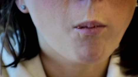 Woman's-mouth-close-up-that-eats-chocolate-and-drinks-coffee