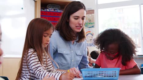 Teacher-sits-with--elementary-schoolchildren-at-art-class