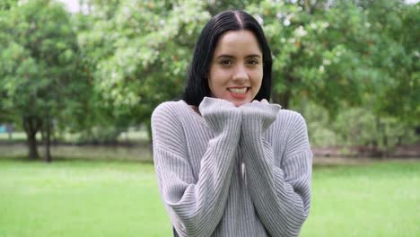 Young-attractive-woman-freezing-and-shivering-in-gray-sweater-in-the-park