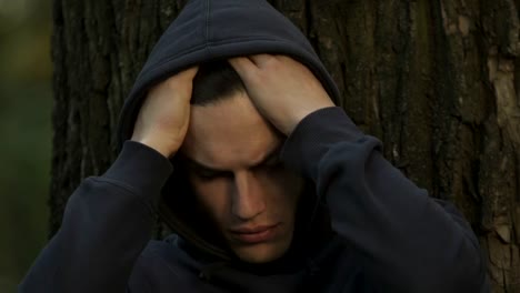 Frustrated-teen-hiding-in-park,-suffering-from-bullying,-communication-problems