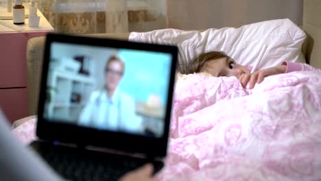 Mamá-con-una-hija-enferma-obtiene-la-consulta-de-un-doctor-utilizando-el-chat-de-video-en-casa.