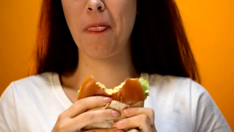 Frau-beißt-unappetitlich-Hamburger,-unzufrieden-mit-der-Qualität-des-Essens,-Nahaufnahme