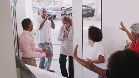 Senior-black-couple-arriving-home-to-a-surprise-family-party,-elevated-view