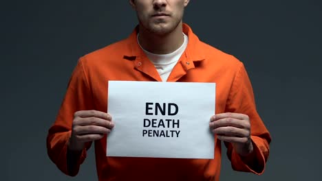 End-death-penalty-phrase-on-cardboard-in-hands-of-Caucasian-prisoner,-protest