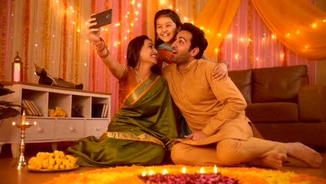 Familia-india-nuclear-celebrando-el-festival-Diwali-y-tomando-un-selfie-de-nuevo-teléfono-inteligente