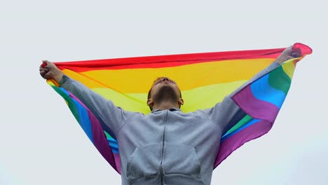 El-hombre-levanta-la-bandera-del-arco-iris,-marcha-por-la-derecha-LGBT,-la-solidaridad-con-el-matrimonio-entre-personas-del-mismo-sexo