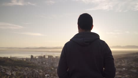 silhouette-shot-of-a-man-flying-his-drone-over-a-city-scape-during-sunrise-on-a-bright-sunny-day-outdoors---futuristic-technology-used-as-personal-hobby