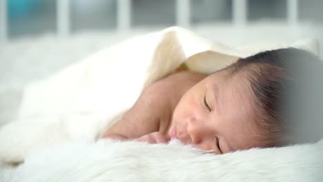 4K-Mittlere-Aufnahme-von-entspannenden-schlafenden-kleinen-asiatischen-Neugeborenen-Baby-Junge-Sohn-liegt-auf-weißem-Bett-mit-Decke-im-Schlafzimmer-zu-Hause.-Süße-unschuldige-Neugeborene-Gesundheit-Pflege-und-empfindliche-Haut-Konzept.