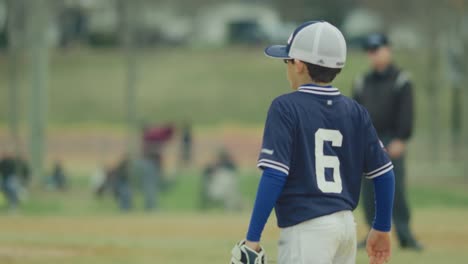 Slow-motion-of-a-kid-moving-on-the-field-during-a-baseball-game