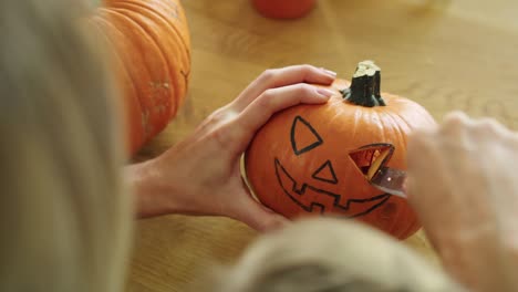 Primer-plano-de-mujer-tallando-calabaza-para-Halloween