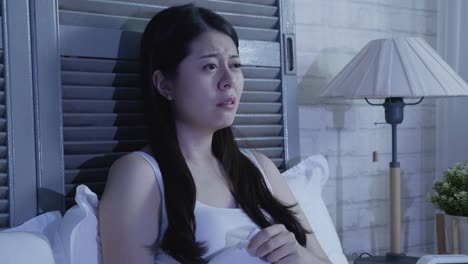 woman-in-dark-bedroom-watching-sad-movie-crying
