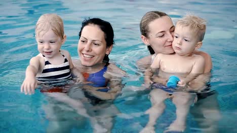 Schwimmbad.-Mütter-bringen-kleinen-Kindern-das-Schwimmen-bei.