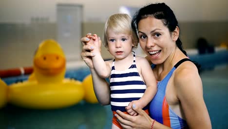 Schwimmbad.-Mama-bringt-einem-kleinen-Kind-das-Schwimmen-im-Pool-bei.