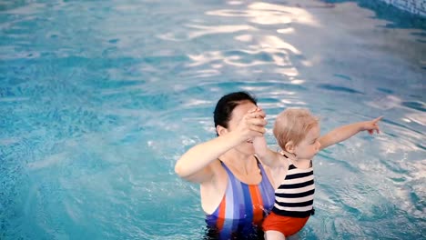 Piscina.-Mamá-le-enseña-a-un-niño-pequeño-a-nadar-en-la-piscina.