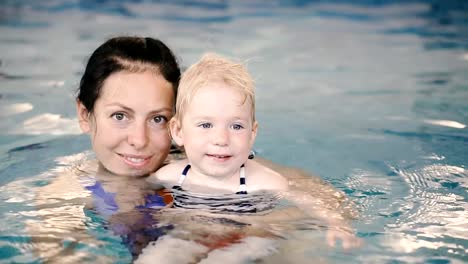 Schwimmbad.-Mama-bringt-einem-kleinen-Kind-das-Schwimmen-im-Pool-bei.