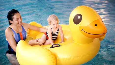 Schwimmbad.-Mama-bringt-einem-kleinen-Kind-das-Schwimmen-im-Pool-bei.