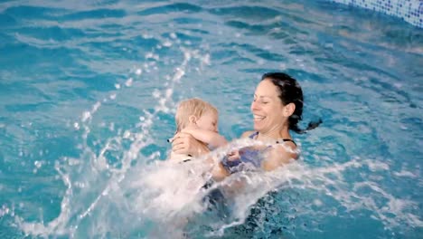 Schwimmbad.-Mama-bringt-einem-kleinen-Kind-das-Schwimmen-im-Pool-bei.