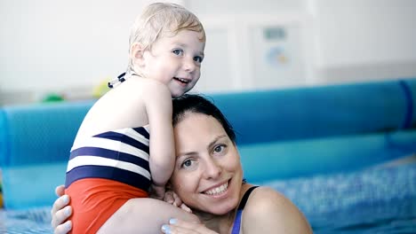 Schwimmbad.-Mama-bringt-einem-kleinen-Kind-das-Schwimmen-im-Pool-bei.