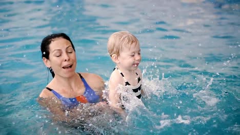 Swimming-pool.-Mom-teaches-a-young-child-to-swim-in-the-pool.