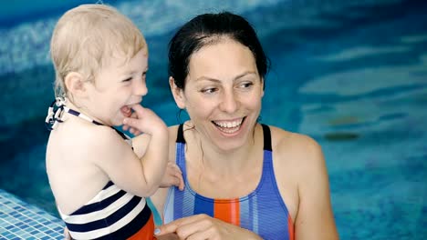 Schwimmbad.-Mama-bringt-einem-kleinen-Kind-das-Schwimmen-im-Pool-bei.