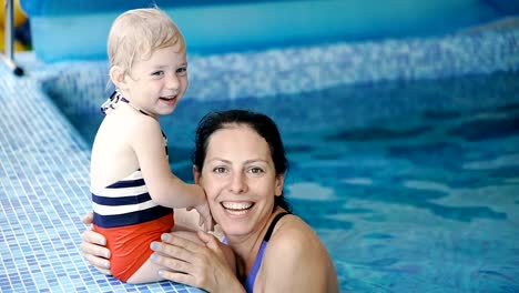 Schwimmbad.-Mama-bringt-einem-kleinen-Kind-das-Schwimmen-im-Pool-bei.