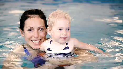 Schwimmbad.-Mama-bringt-einem-kleinen-Kind-das-Schwimmen-im-Pool-bei.