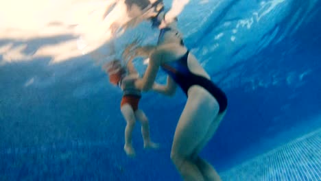 Swimming-pool.-Mom-teaches-a-young-child-to-swim-in-the-pool.