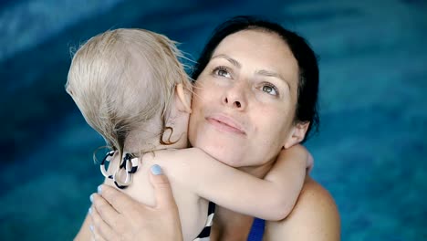 Schwimmbad.-Mama-bringt-einem-kleinen-Kind-das-Schwimmen-im-Pool-bei.