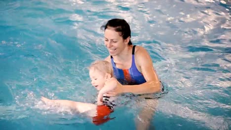 Schwimmbad.-Mama-bringt-einem-kleinen-Kind-das-Schwimmen-im-Pool-bei.